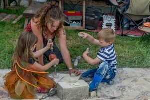 woman and two children, hand drill, craft