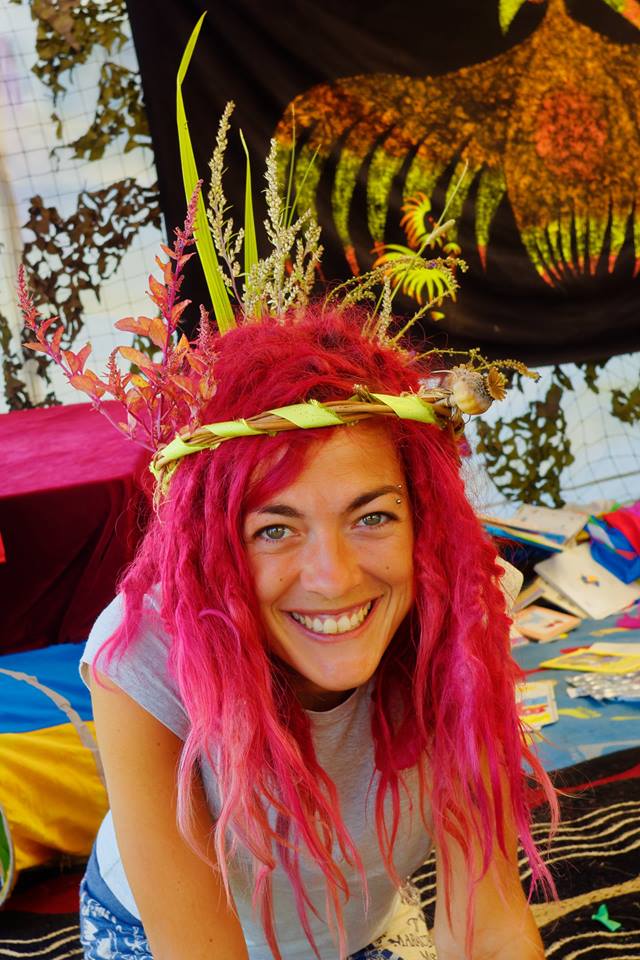 Smiling woman with pink hair and head-dress 